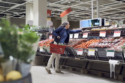 Woman buying vegetables from supermarket