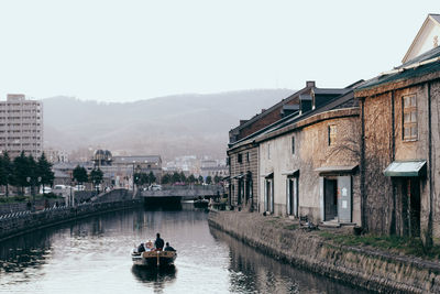 Boats in river with buildings in background