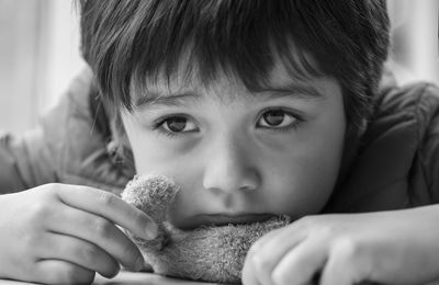 Close-up of sad boy holding toy