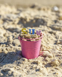 Close-up of toy on sand in bucket at beach