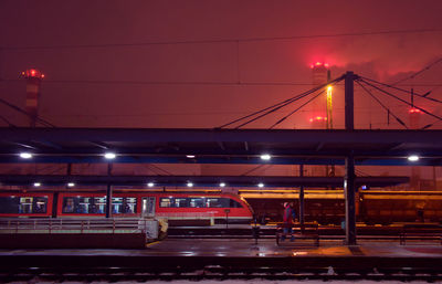 Train in illuminated railroad station at night