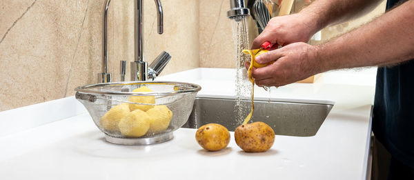 Cropped hand of person preparing food on table