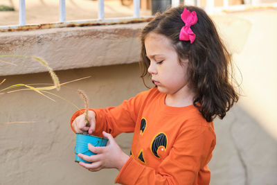 Little girl playing with bucket and plant seeds in the back yard