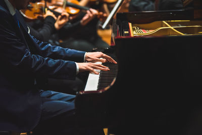 Midsection of man playing piano