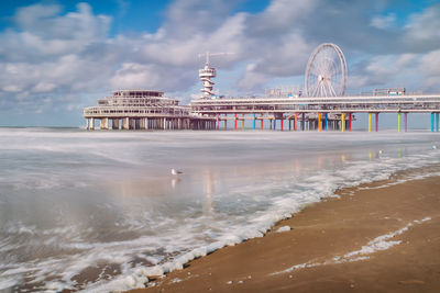 Building by sea against cloudy sky