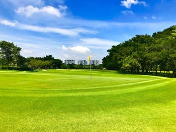 Scenic view of golf course against sky