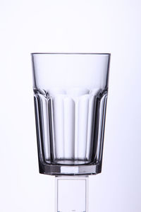 Close-up of empty drinking glass against white background