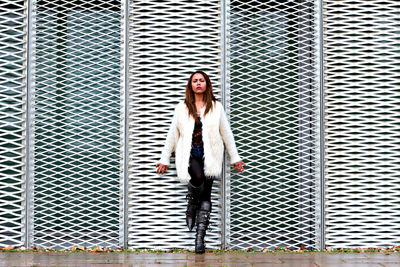 Portrait of woman standing against wall