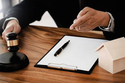 Midsection of man using mobile phone on table