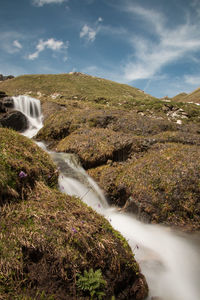 Scenic view of waterfall against sky