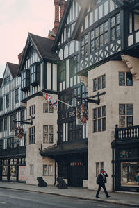 Man walking on street against buildings in city