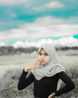 Portrait of a beautiful young woman standing on land