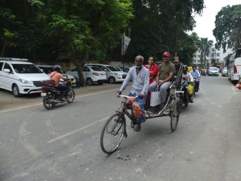 People riding bicycle on road in city