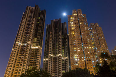 Low angle view of illuminated skyscrapers against sky at night