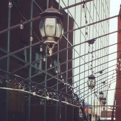 Low angle view of illuminated hanging lights against sky