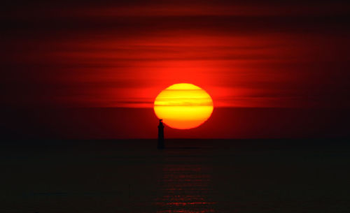 Scenic view of sea against orange sky during sunset
