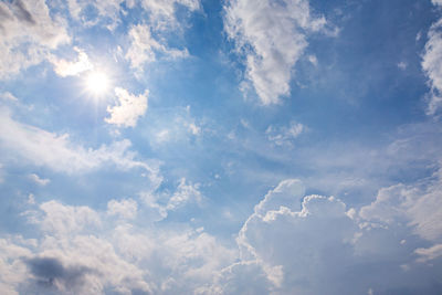 Low angle view of sunlight streaming through clouds