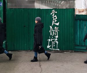 Rear view of people walking on wall