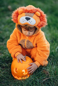 Full length of boy with pumpkin on field