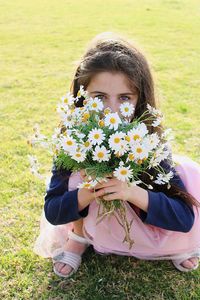 Full length of woman with flowers on field