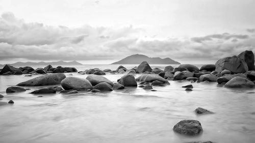 The rocks, waves, clouds and sky at kura-kura beach, singkawang - west of kalimantan.