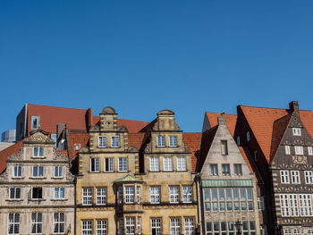 Low angle view of buildings against clear blue sky