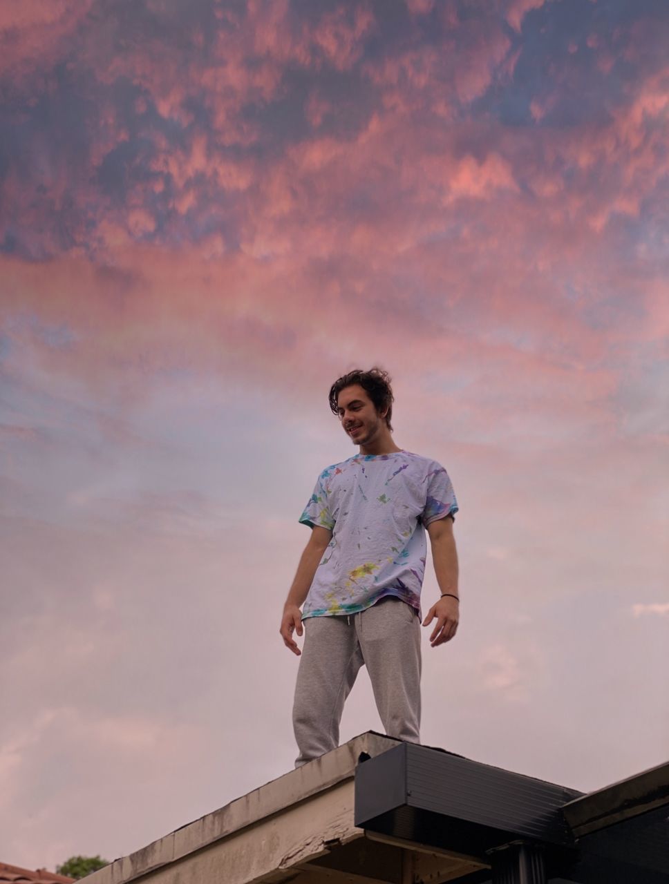 LOW ANGLE VIEW OF YOUNG WOMAN STANDING AGAINST SKY