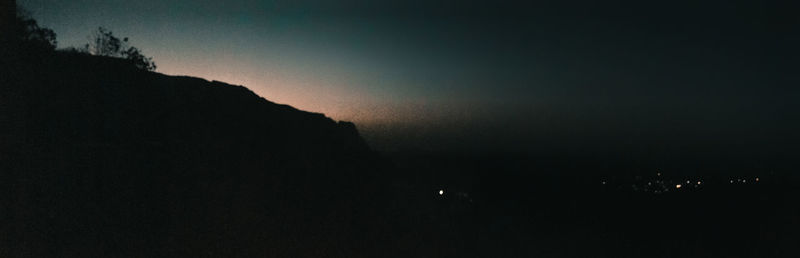 Silhouette landscape against clear sky at night