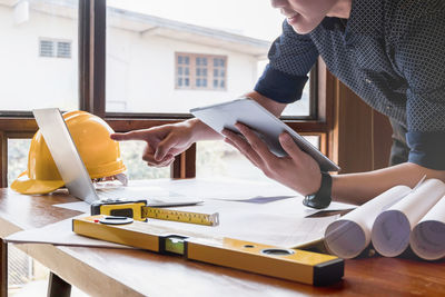 Midsection of engineer working on table