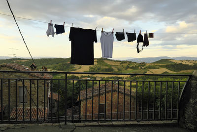 Clothes drying on railing against sky