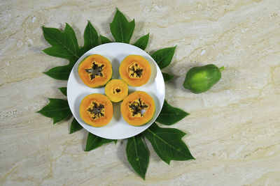 High angle view of fruits and leaves on table