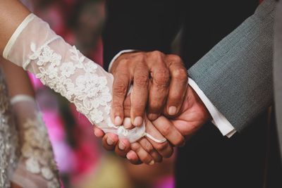 Cropped image of people holding hands at wedding ceremony