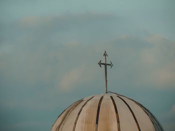 Low angle view of weather vane against sky