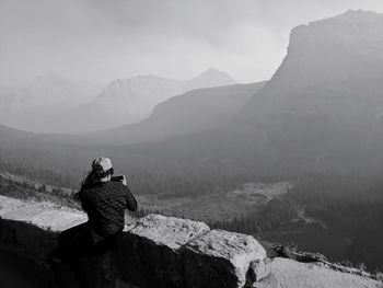 Female photographing scenic overlook along going to the sun road in glacier national park