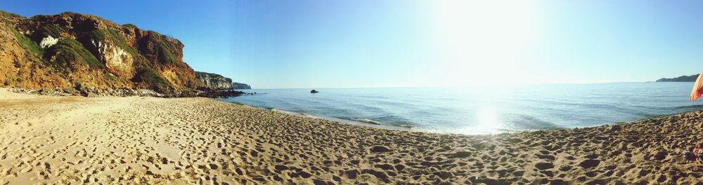 Scenic view of beach against clear blue sky