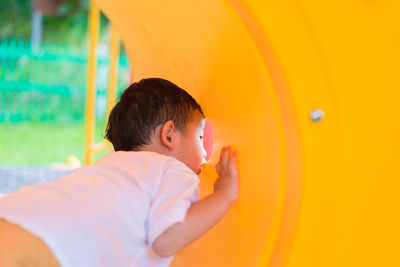 Portrait of boy holding yellow orange