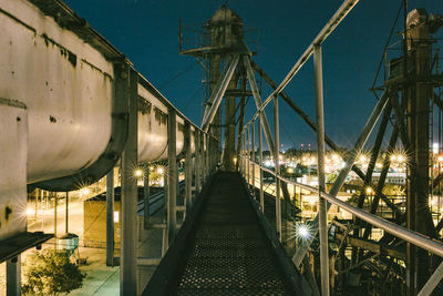 Illuminated bridge against sky at night