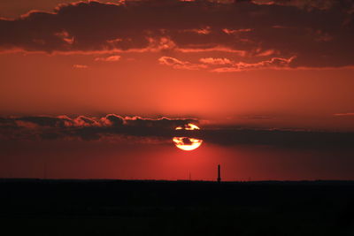 Scenic view of silhouette landscape against orange sky