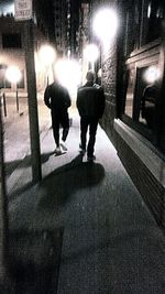 Silhouette people walking on wet road during rainy season