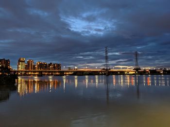 Reflection of buildings in lake against sky at dusk
