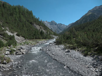 Scenic view of river by mountains against sky