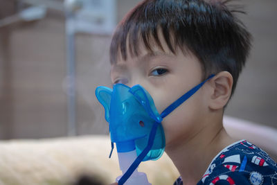 Portrait of cute boy wearing oxygen mask in hospital