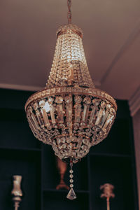 Low angle view of illuminated chandelier hanging on ceiling in building
