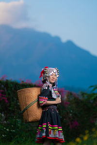 Full length of woman standing in basket against mountain