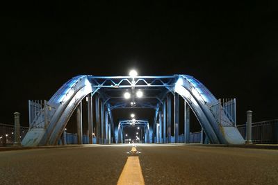Illuminated bridge against sky at night