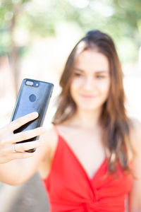 Close-up of smiling woman taking selfie through smart phone 