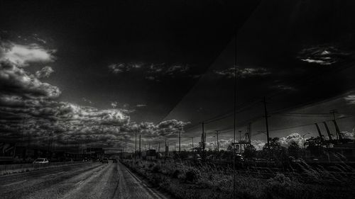 Road on field against cloudy sky