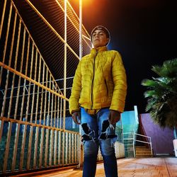 Full length of boy standing against railing