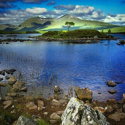 water, tranquil scene, tranquility, lake, sky, mountain, scenics, beauty in nature, nature, reflection, lakeshore, cloud - sky, landscape, mountain range, cloud, idyllic, non-urban scene, grass, rock - object, blue