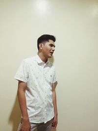 Young man standing against wall